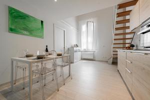 kuchnia ze stołem i krzesłami w pokoju w obiekcie Realkasa Luxury S.Orsola Apartments w Bolonii