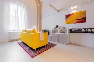salon z żółtą kanapą i kuchnią w obiekcie Realkasa Luxury S.Orsola Apartments w Bolonii +37 zdjęć