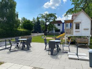 a patio with tables and chairs and a play house at La Maison Pritzwalk - Bett & Bike in Pritzwalk +41 photos
