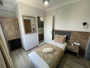 a small bedroom with a bed and a television at Seven City Hotel in Antalya