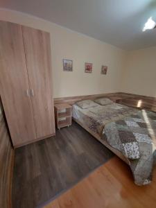 um quarto com uma cama e um armário de madeira em Svetlana em Lazarevskoye
