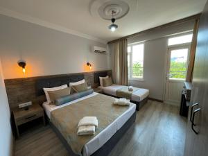 1 dormitorio con 2 camas y toallas. en Seven City Hotel en Antalya