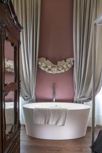 een wit bad in een kamer met gordijnen bij Casa Botticelli in Florence +72 foto's