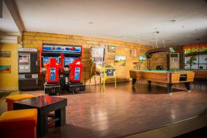 a room with a pool table and two arcade machines at Hotel Majestic Mamaia Half Board & All Inclusive in Mamaia