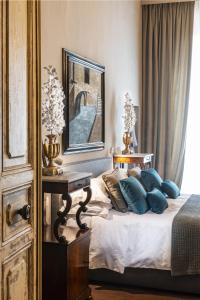 a bedroom with a bed with blue pillows and a mirror at Casa Botticelli in Florence