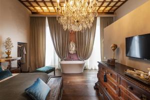 un soggiorno con lampadario pendente e vasca da bagno di Casa Botticelli a Firenze