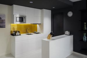 a kitchen with white cabinets and a clock on the wall at Staybridge Suites Al Khobar by IHG in Al Khobar