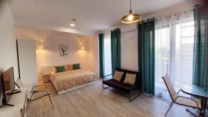 a bedroom with a bed and a table with a chair at MIKA Studios in Eforie Nord