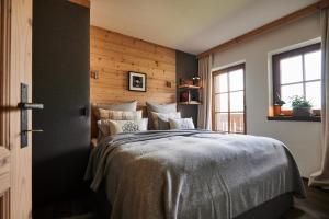 a bedroom with a bed and a wooden wall at Serviced Luxury Chalet Evi, Ski-in Ski-out in Kaprun