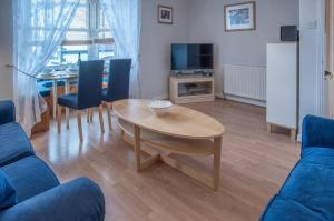 a living room with a table and a dining room at Starfish Apartment - 2 Bedroom Apartment - Tenby in Tenby