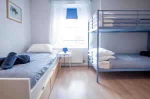 a bedroom with two bunk beds and a window at Starfish Apartment - 2 Bedroom Apartment - Tenby in Tenby