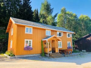ein kleines orangefarbenes Haus mit einer Bank davor in der Unterkunft Bakarstuo, Utpå Neset in Trofors