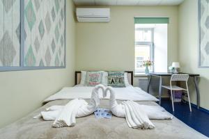 um quarto com uma cama com dois cisnes feitos de toalhas em Никитская капсула - сердце Москвы em Moscou
