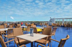 DFDS Mini Cruise Amsterdam - Newcastle - Amsterdam في آيماودن: فناء به طاولات وكراسي على السطح