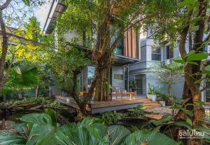 a house with a tree on the front of it at Wara Boutique Hotel in Udon Thani