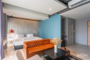 a bedroom with a bed and a couch and a table at Wara Boutique Hotel in Udon Thani