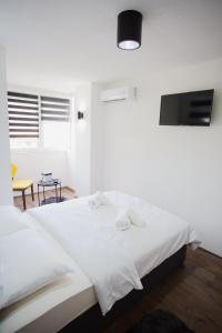 ein Schlafzimmer mit einem weißen Bett und Handtüchern darauf in der Unterkunft MOKAA Apartment in Mostar