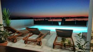 twee stoelen en een tafel en een zwembad bij Kuća za odmor in Privlaka