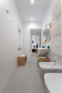 uma casa de banho branca com 2 lavatórios e um espelho em HSuites Luxury B&B em Castellammare di Stabia