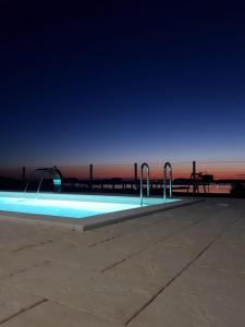 een zwembad 's nachts met een pier op de achtergrond bij Kuća za odmor in Privlaka