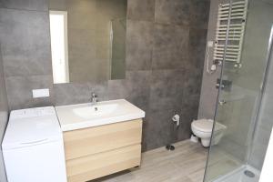 a bathroom with a sink and a shower and a toilet at Apartament Sopot in Sopot