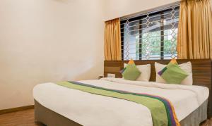 a bedroom with two beds and a window at Treebo Trend Five Elements Lonavala in Lonavala
