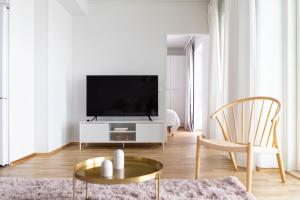 uma sala de estar com uma televisão de ecrã plano num armário branco em Roost Rautatienkatu #12 em Oulu