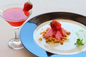 a plate with a strawberry dessert and a drink at Hotel Baia Imperiale in Campo nell'Elba