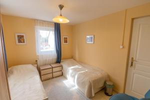 a bedroom with two beds and a window at Kamala Kutir in Somogyvámos