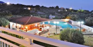 una villa con piscina por la noche en Primavera Paradise Apartments, en Agios Nikolaos