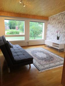 uma sala de estar com um sofá e duas janelas em RBA RentHouse Apartment 3 em Nedervetil