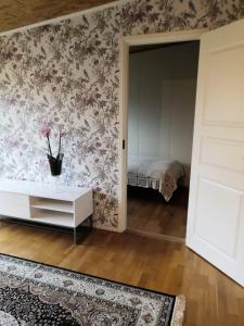 a room with a bedroom with floral wallpaper at RBA RentHouse Apartment 3 in Nedervetil