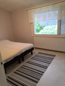 um quarto com uma cama, uma janela e um tapete em RBA RentHouse Apartment 3 em Nedervetil