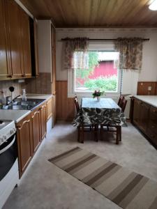 uma cozinha com uma mesa, um lavatório e uma janela em RBA RentHouse Apartment 3 em Nedervetil