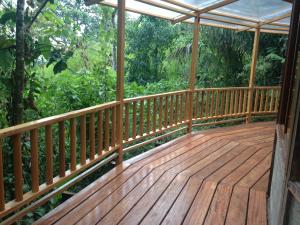 una terraza de madera con vistas al bosque en Pacoche Lodge, en Pacoche