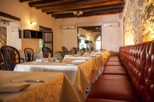 une rangée de tables dans un restaurant avec un tissu de table jaune dans l'établissement Hotel Monterrey, à Carthagène des Indes