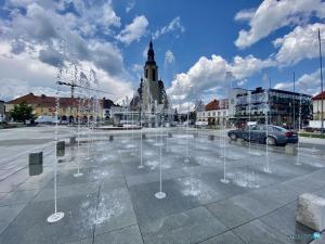 a water fountain in a parking lot in a city at M37 Apartment Limanowa Beskid Base in Limanowa