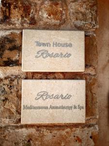 three signs on a brick wall at Town House Rosario in Stari Grad