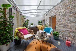 d'une terrasse avec des chaises en osier, une table et des plantes. dans l'établissement Hôtel Veryste & Spa Paris, à Paris