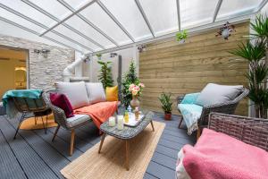 a patio with chairs and tables and a white roof at Hôtel Veryste & Spa Paris in Paris