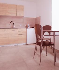 eine Küche mit einem Tisch und Stühlen sowie einem Kühlschrank in der Unterkunft Pokoje Gościnne 2 in Danzig