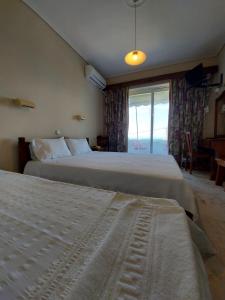 pokój hotelowy z 2 łóżkami i oknem w obiekcie Batis Hotel w mieście Livanátai