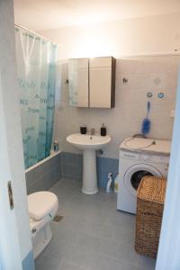 y baño con aseo, lavabo y lavadora. en OLIVES Estate APARTMENTS Grande en Preveza