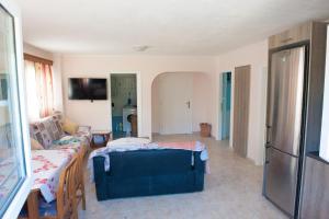 uma sala de estar com um repousa-pés azul e um sofá em OLIVES Estate APARTMENTS Grande em Preveza