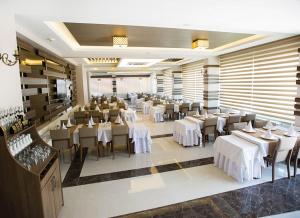 un comedor con mesas y sillas blancas en Lavin Hotel & Spa, en Denizli