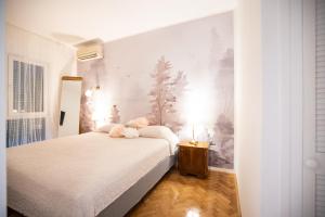 - une chambre avec un lit blanc orné de fleurs dans l'établissement Apartman Klara Zadar - Jazine, à Zadar