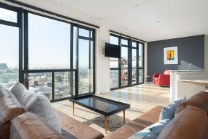 a living room with a couch and a table at Four Seasons Apartments in Cape Town