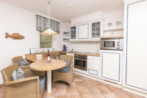 a kitchen with a table and chairs in a room at Villa Strandperle Nr. 17 in Binz