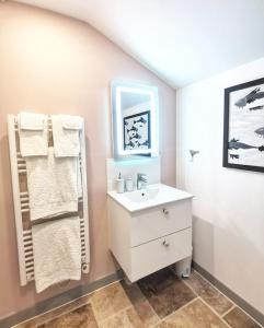 y baño con lavabo blanco y espejo. en La Maison Verte, en Siorac-de-Ribérac