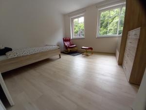 a bedroom with a bed and a chair and two windows at Alte Mühle in Holzminden